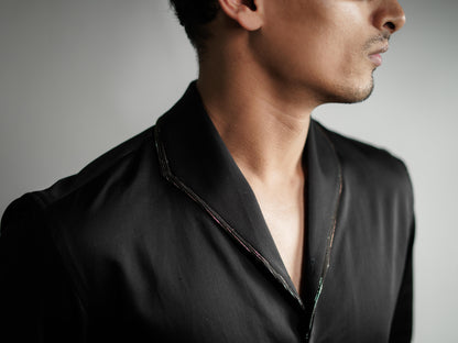Man wearing a black shirt against a gray background